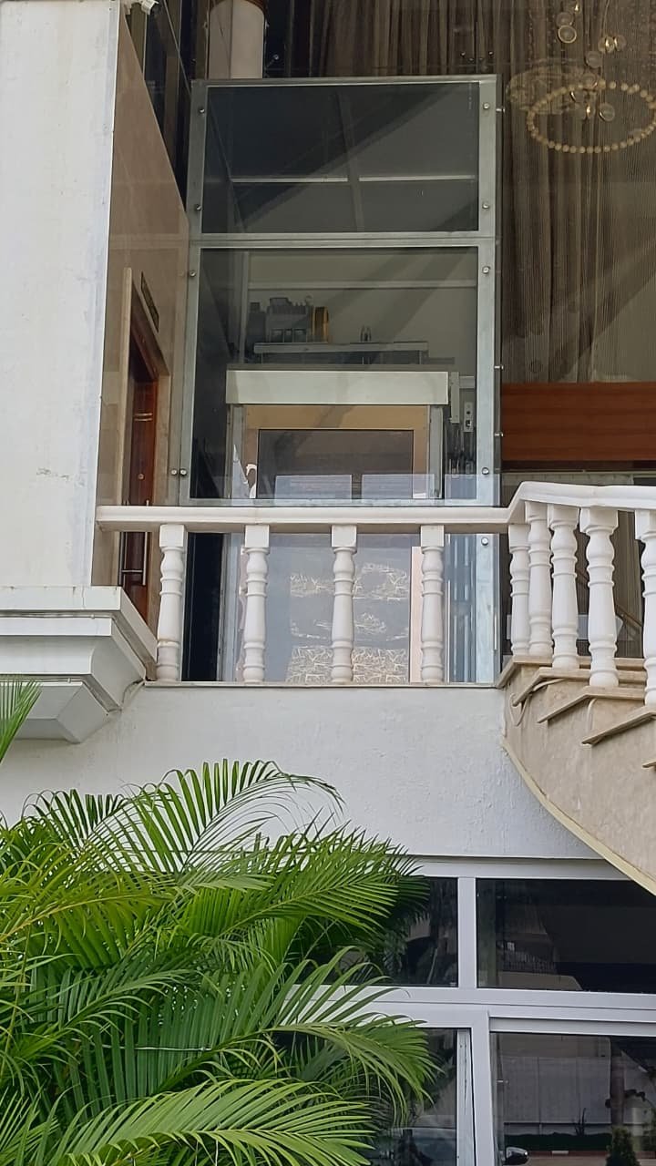 Outdoor glass elevator installed by Ambara Elevators beside a residence balcony